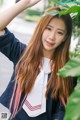 A young woman in a school uniform posing for a picture.