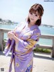 A woman in a purple kimono posing for a picture.