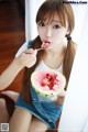 A young woman eating a slice of watermelon with a spoon.