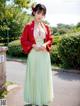 A woman in a green and red kimono posing for a picture.