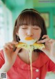 A woman eating a piece of food with an egg on it.