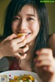 A woman sitting at a table with a plate of food.