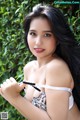 A woman in a white bra and black panties posing for a picture.
