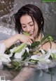 A woman laying in a bathtub with white flowers.