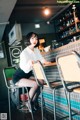 A woman sitting at a bar in a restaurant.