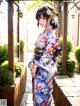 A woman in a kimono standing in front of a building.